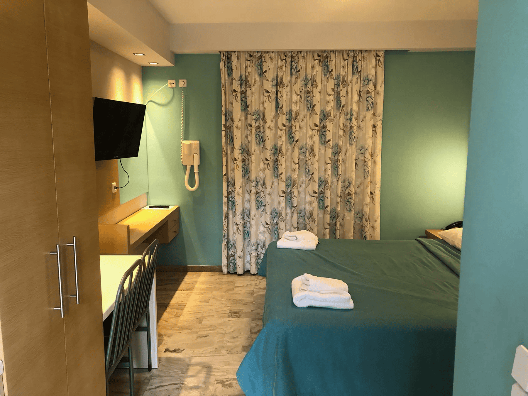 a bedroom with a bed and a television