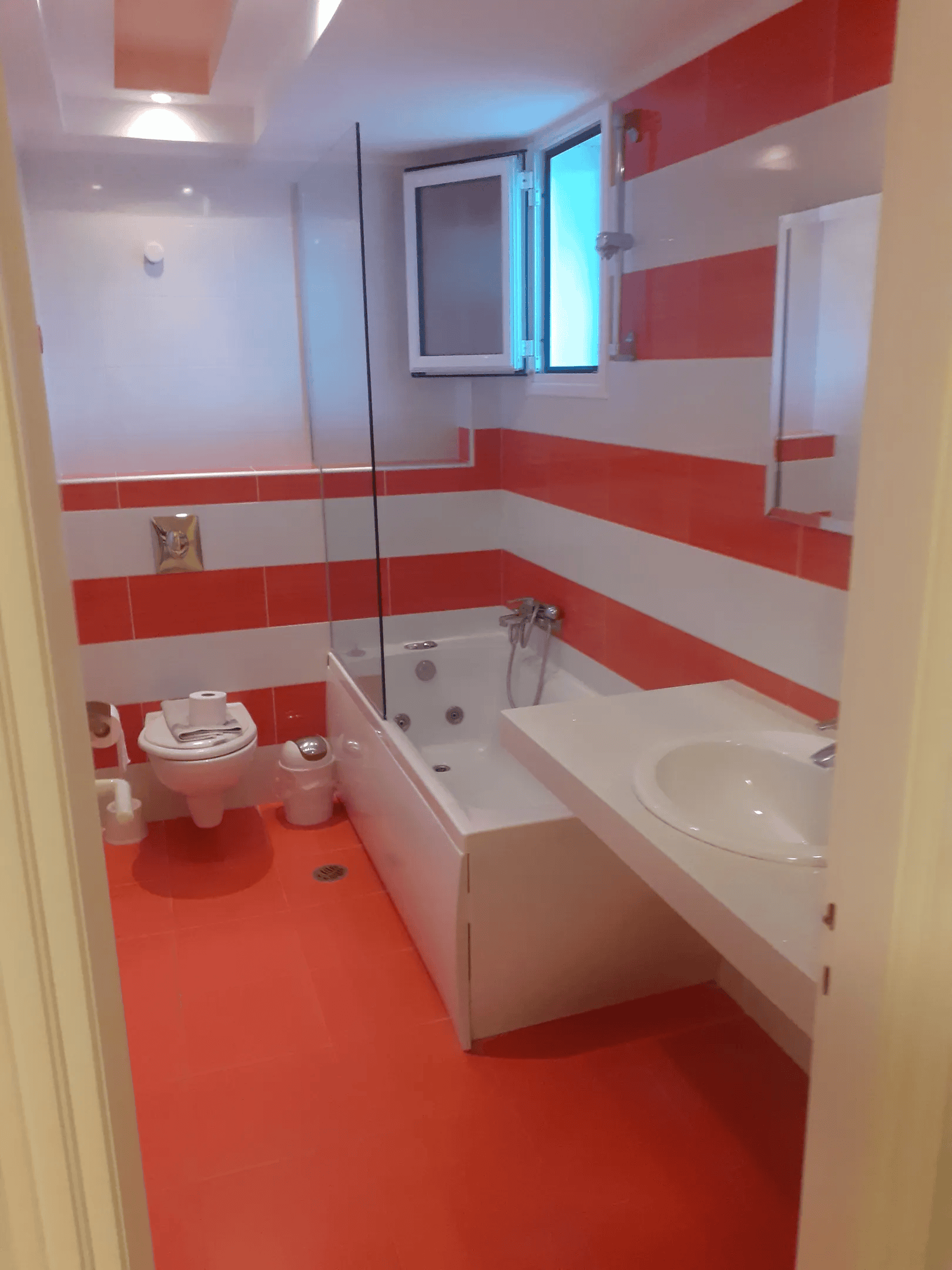 a bathroom with red flooring