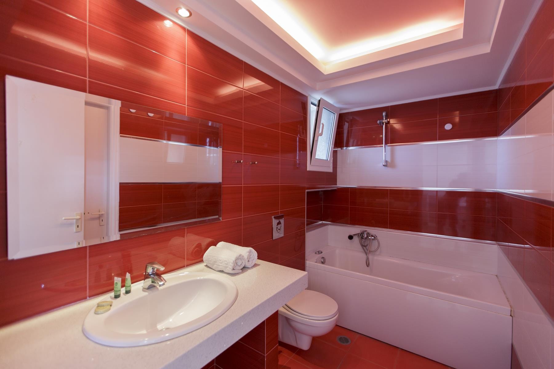 a bathroom with a red tile wall