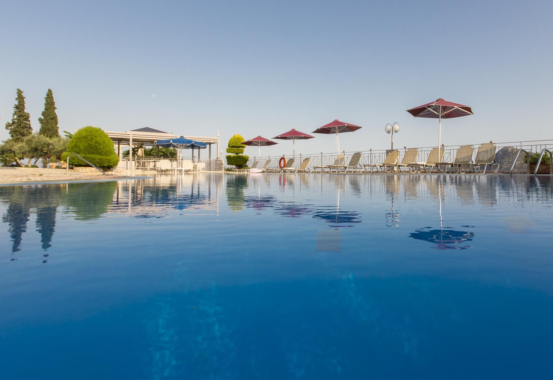 a body of water with umbrellas and chairs by it