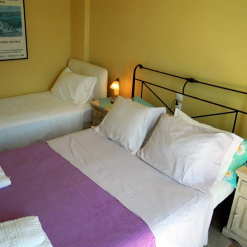 a couple of beds with white sheets