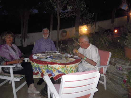 a group of people sitting around a table with food on it