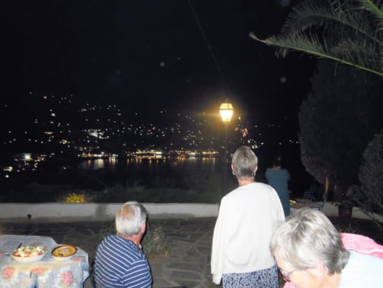 people sitting at a table with food and a city in the background