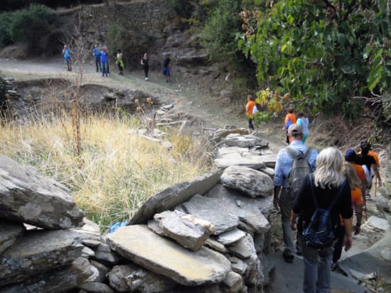 a group of people walking on a rocky path