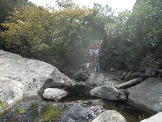 a couple of people standing on a rocky river bed