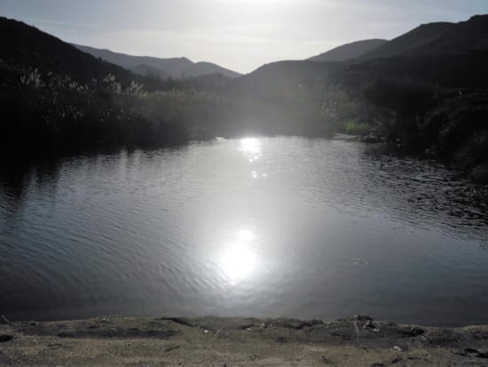 a body of water with mountains in the background with Boiling Lake in the background