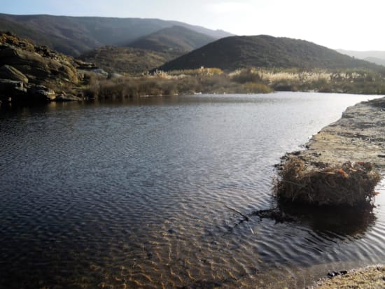 a body of water with hills in the background