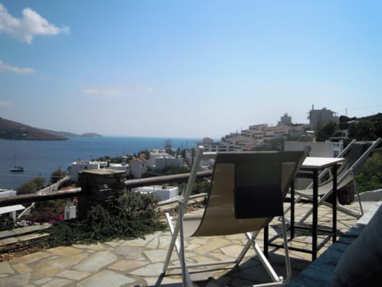 a patio with chairs and tables overlooking a body of water
