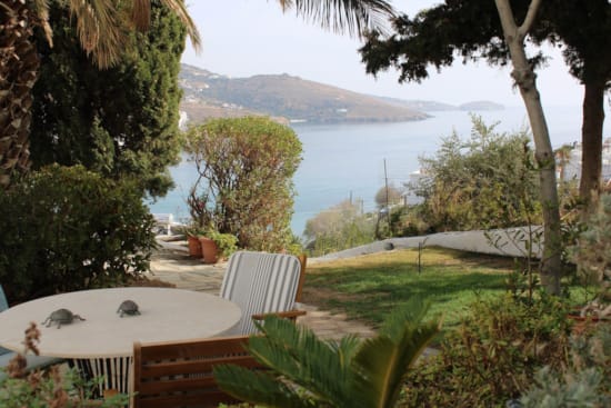 a table and chairs on a deck overlooking a body of water