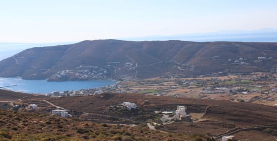 a landscape with hills and a body of water in the distance