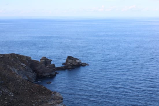 a rocky beach with a body of water in the background