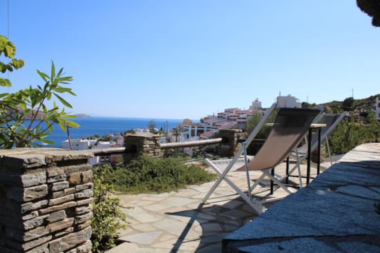 a deck with chairs and a view of the ocean