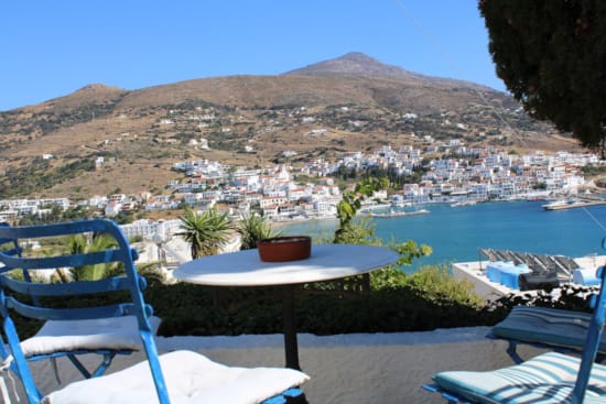 a table and chairs on a deck overlooking a town and mountains