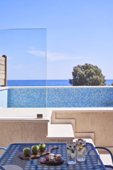 a table with food and glasses on it by a pool