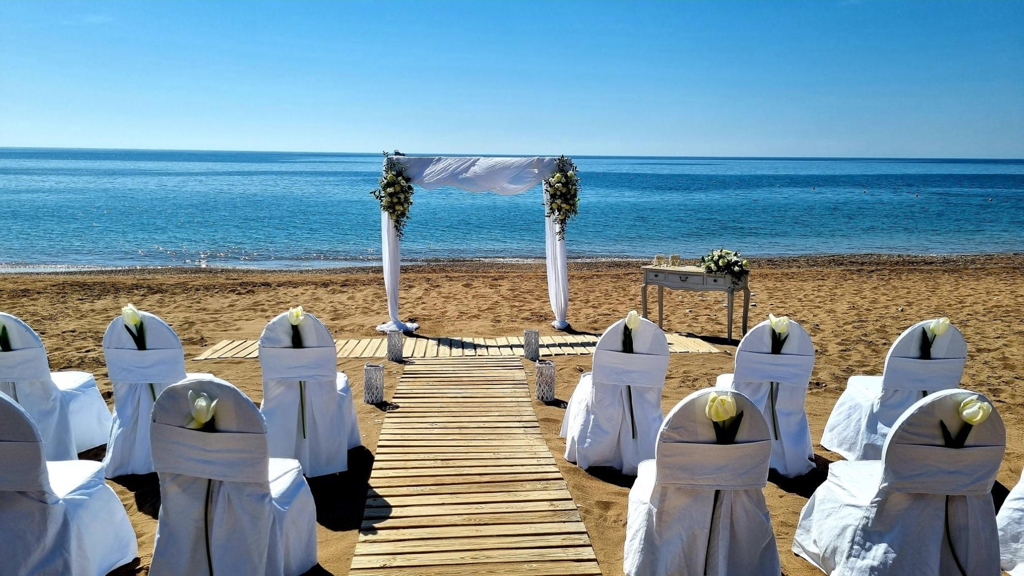 a group of white chairs on a beach
