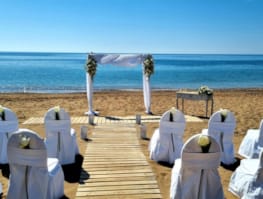 a group of white chairs on a beach