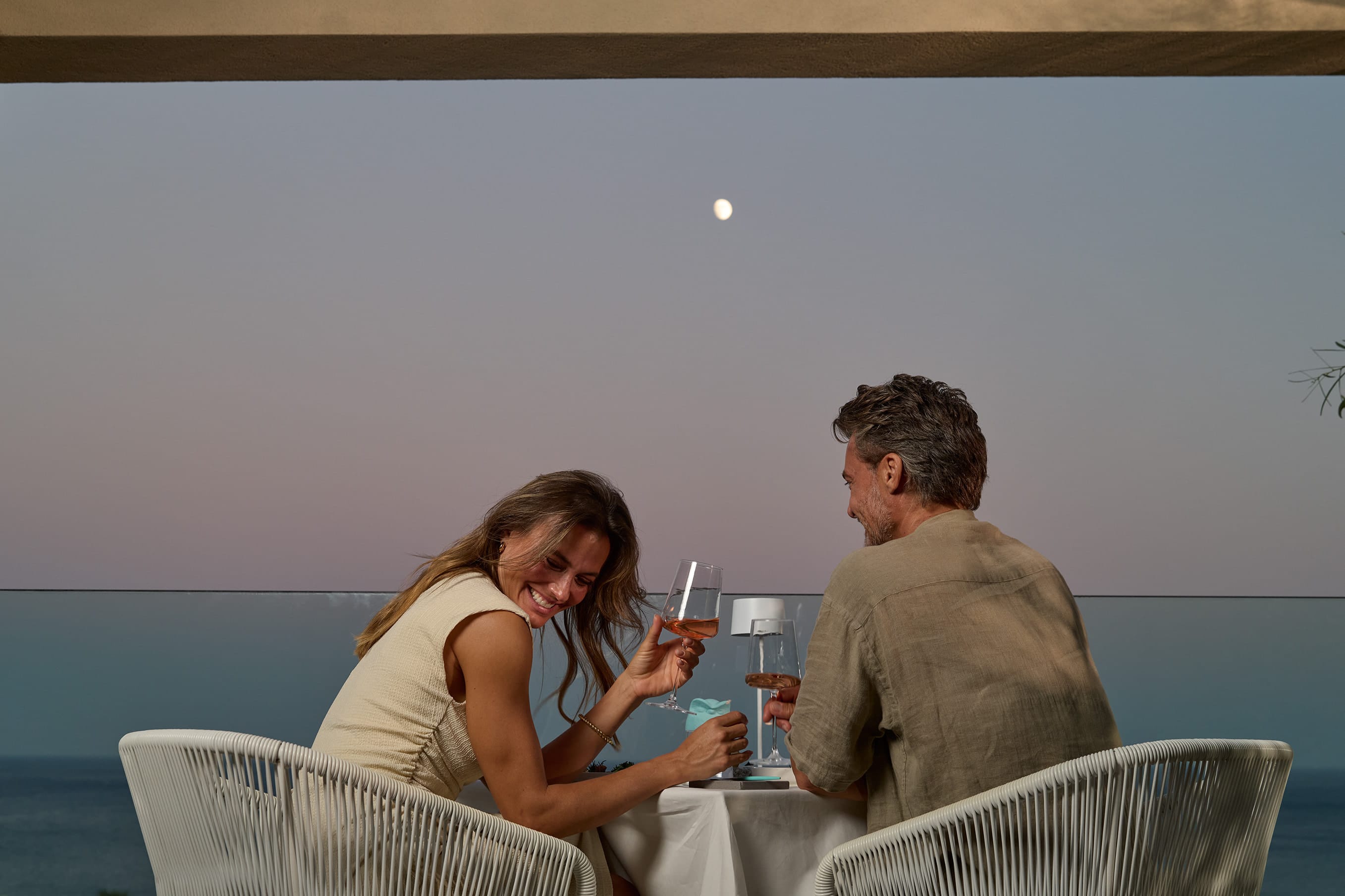 a man and woman sitting at a table with drinks
