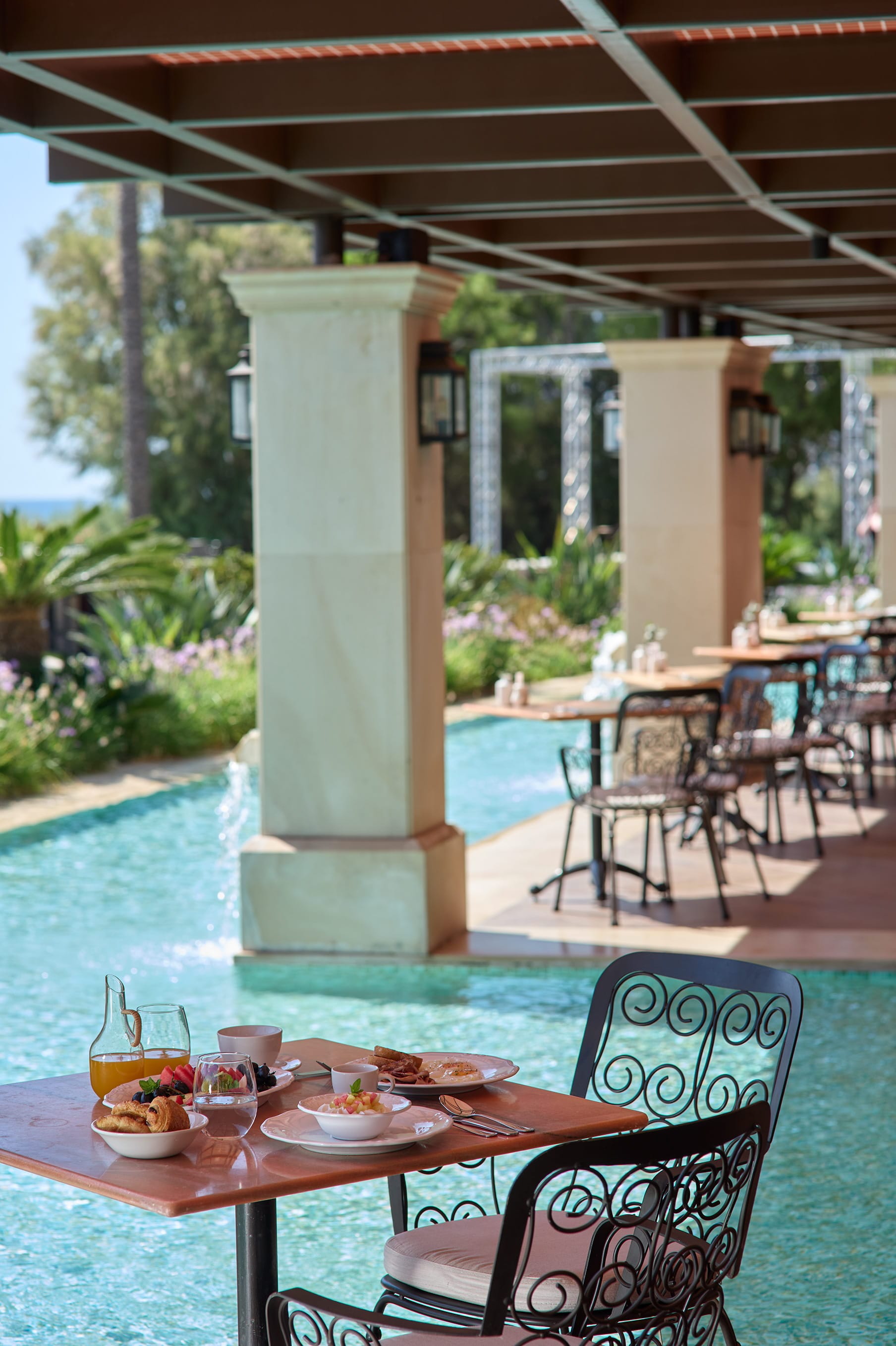 a table with food and drinks on it by a pool