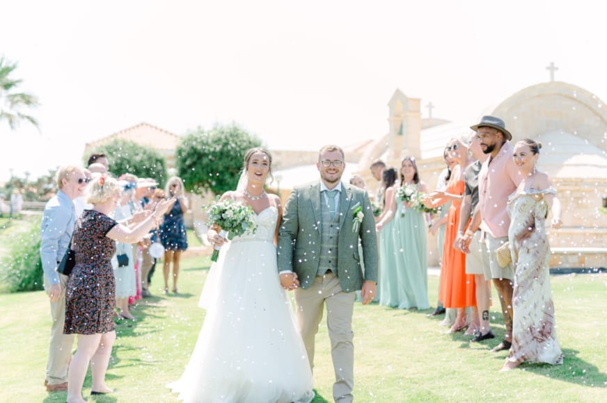 a group of people walking down a path with a man in a suit and a woman in a