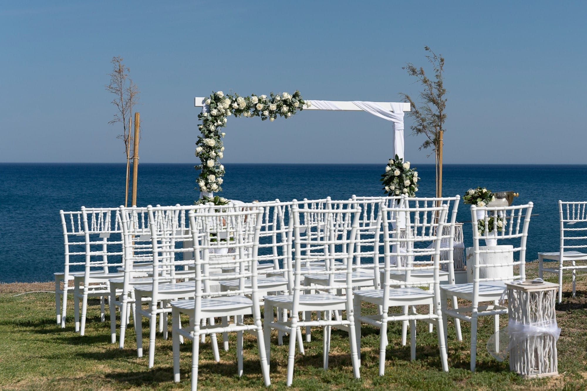 a row of white chairs on a beach