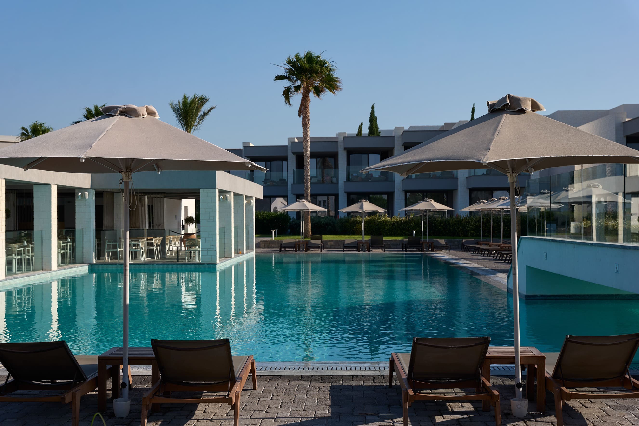 a pool with umbrellas and chairs next to it