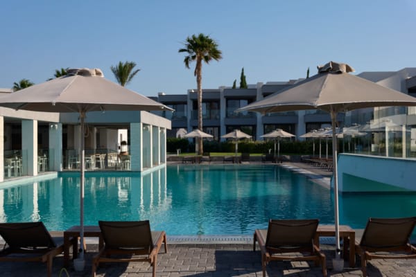 a pool with umbrellas and chairs next to it