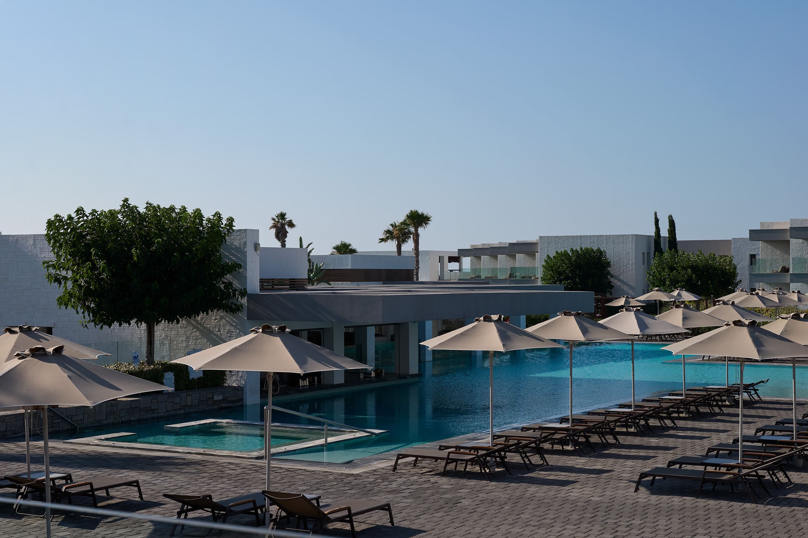 a pool with umbrellas and chairs next to it