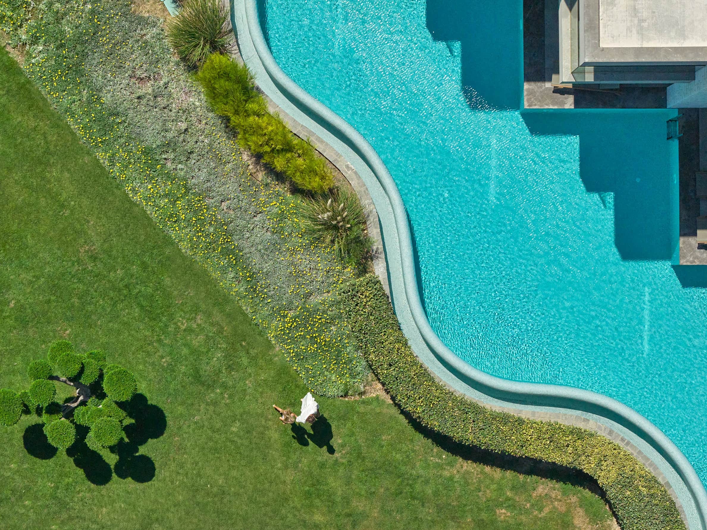 a person sitting on a lawn next to a body of water