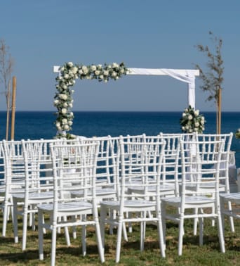 a row of white chairs on a beach