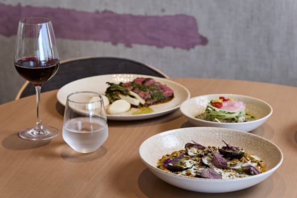 a table with plates of food and glasses of wine