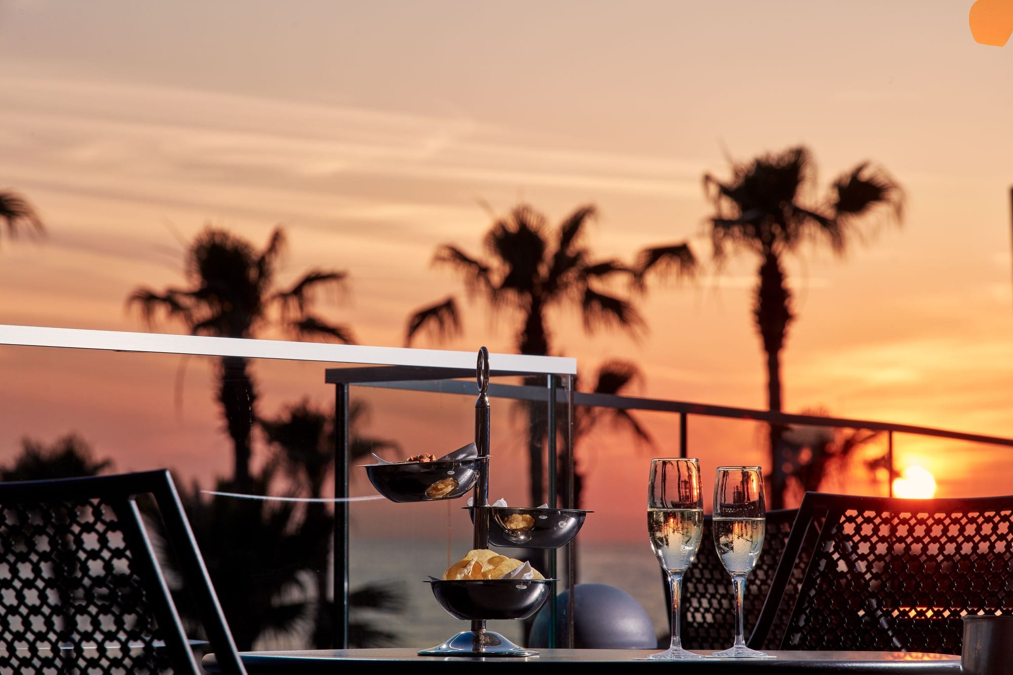 a table with wine glasses and chairs