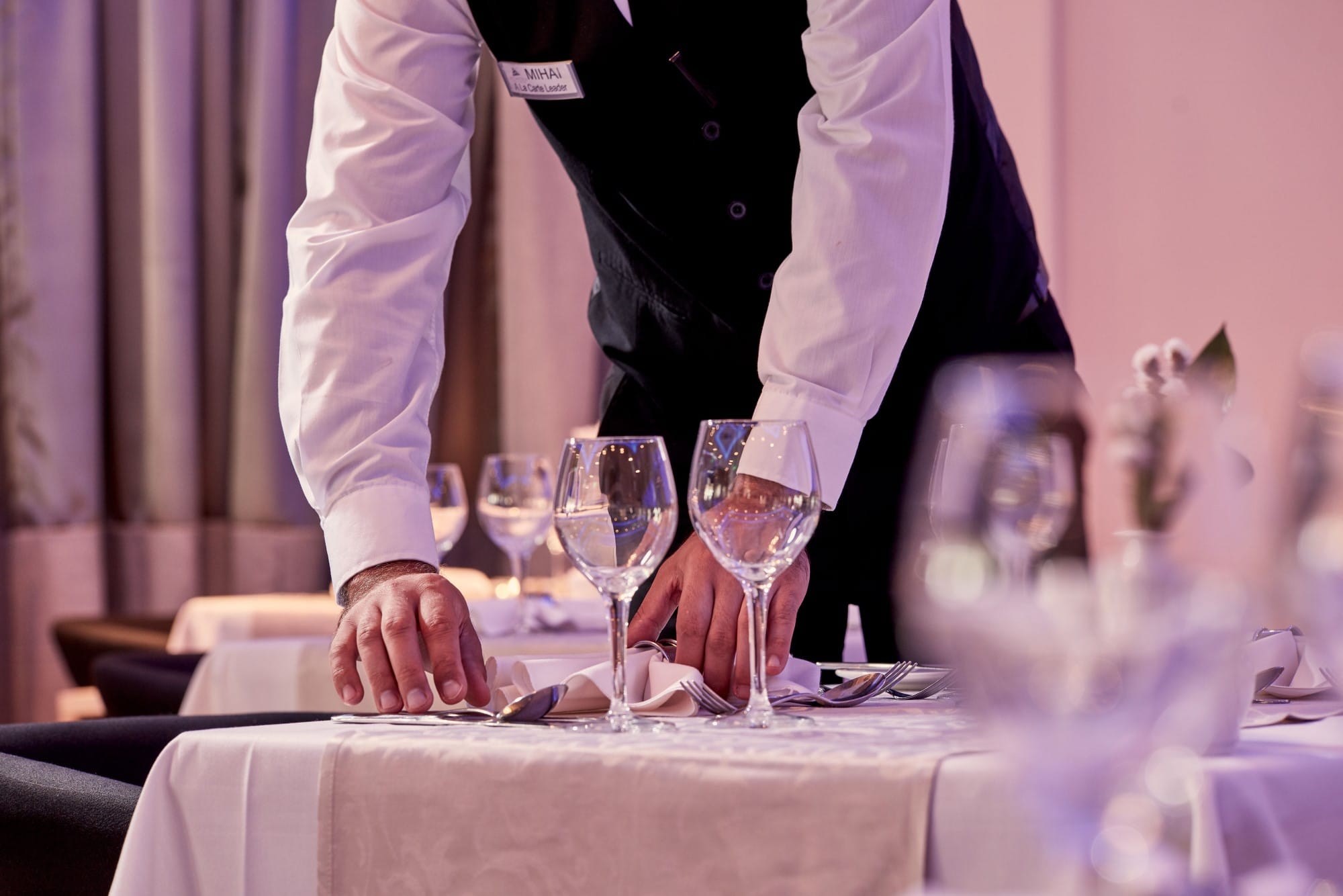 a person pouring wine into glasses