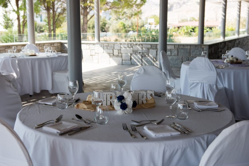 a set dining table with white cloths and silverware