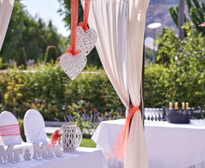 a table with white tables and white cloths and red and white cloths