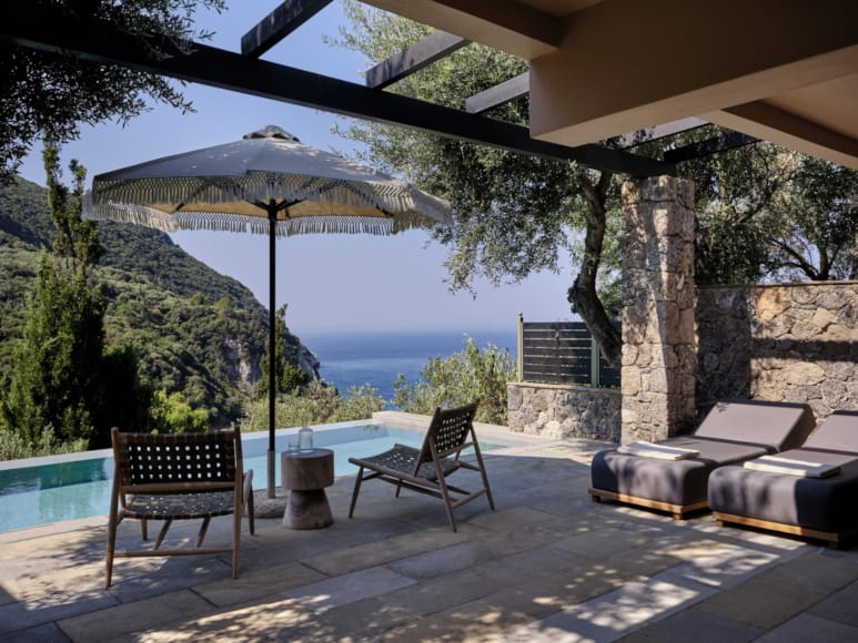 a patio with chairs and umbrella