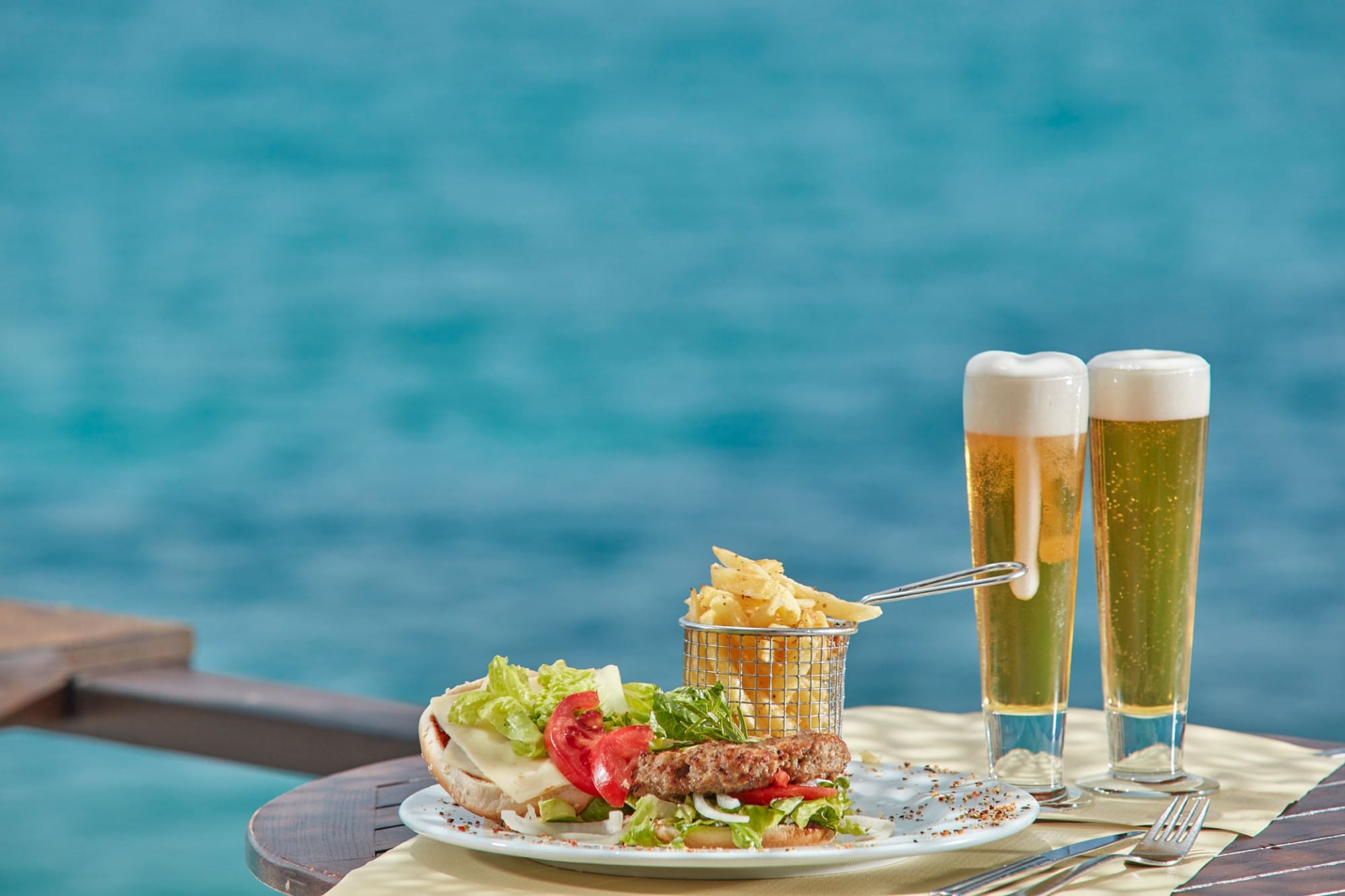 a plate of food and glasses of beer on a table