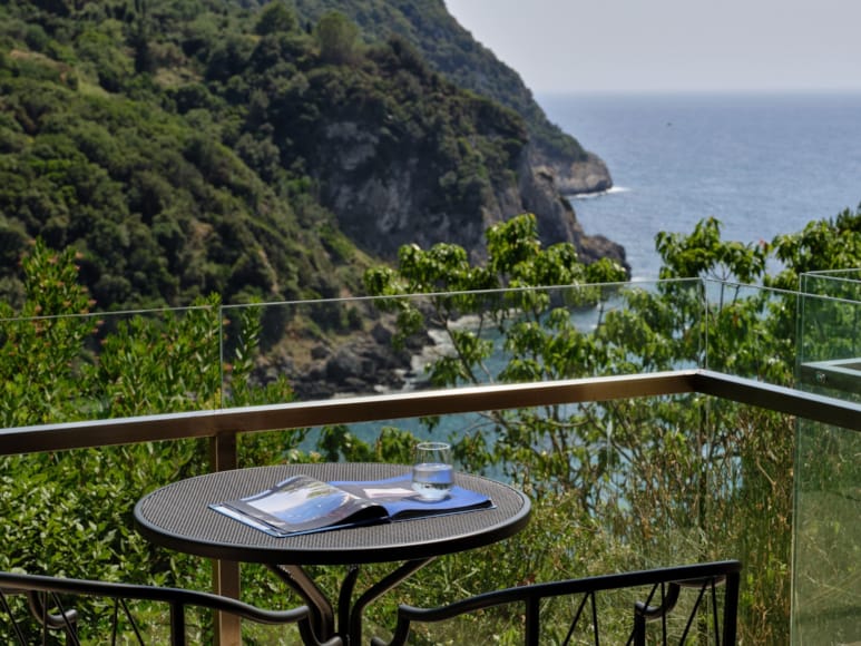 a table and chairs on a balcony overlooking a body of water