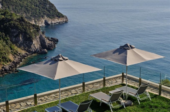 a group of chairs and umbrellas by a body of water