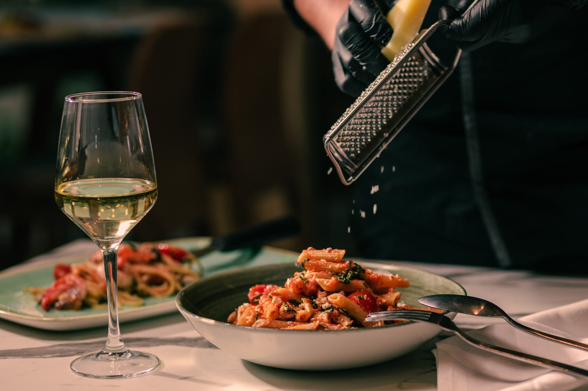 a table with plates of food and a glass of wine