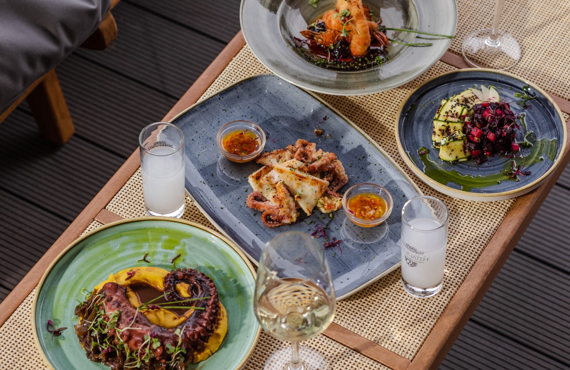 a table with plates of food and glasses of wine