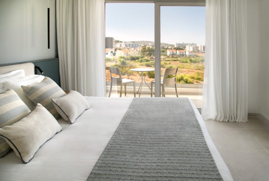 a room with a bed and chairs