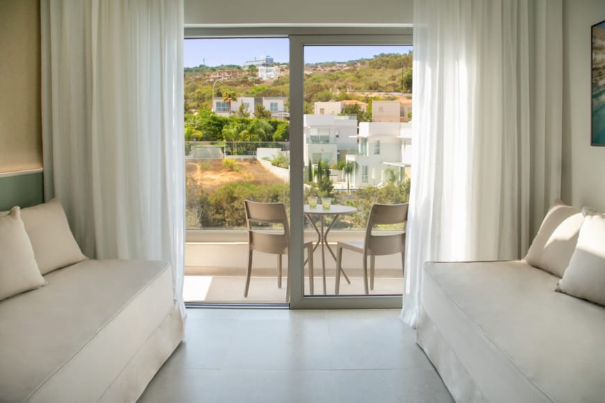 a room with a table chairs and a window with a view of a city