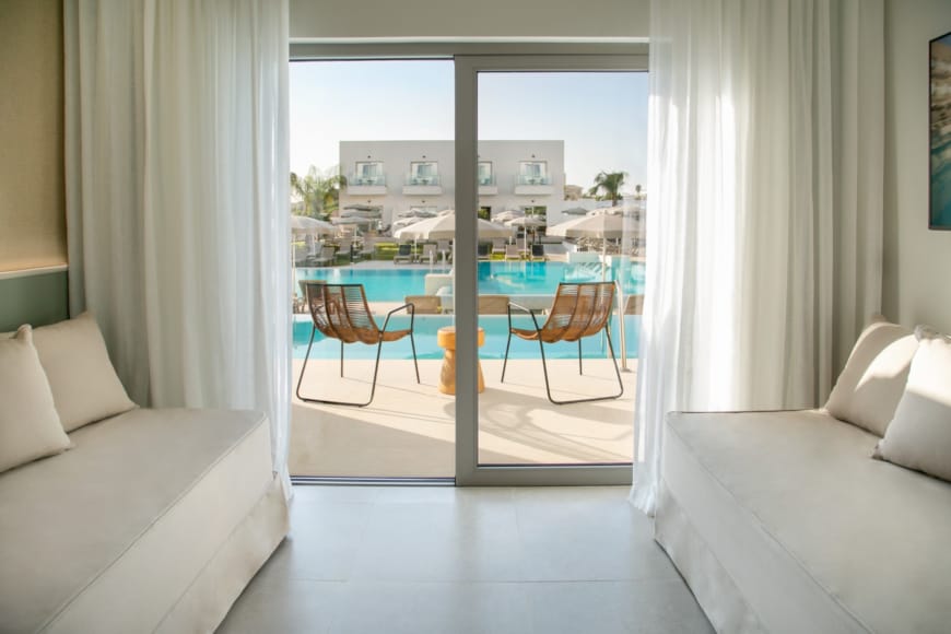 a room with a table chairs and a window with a view of the city