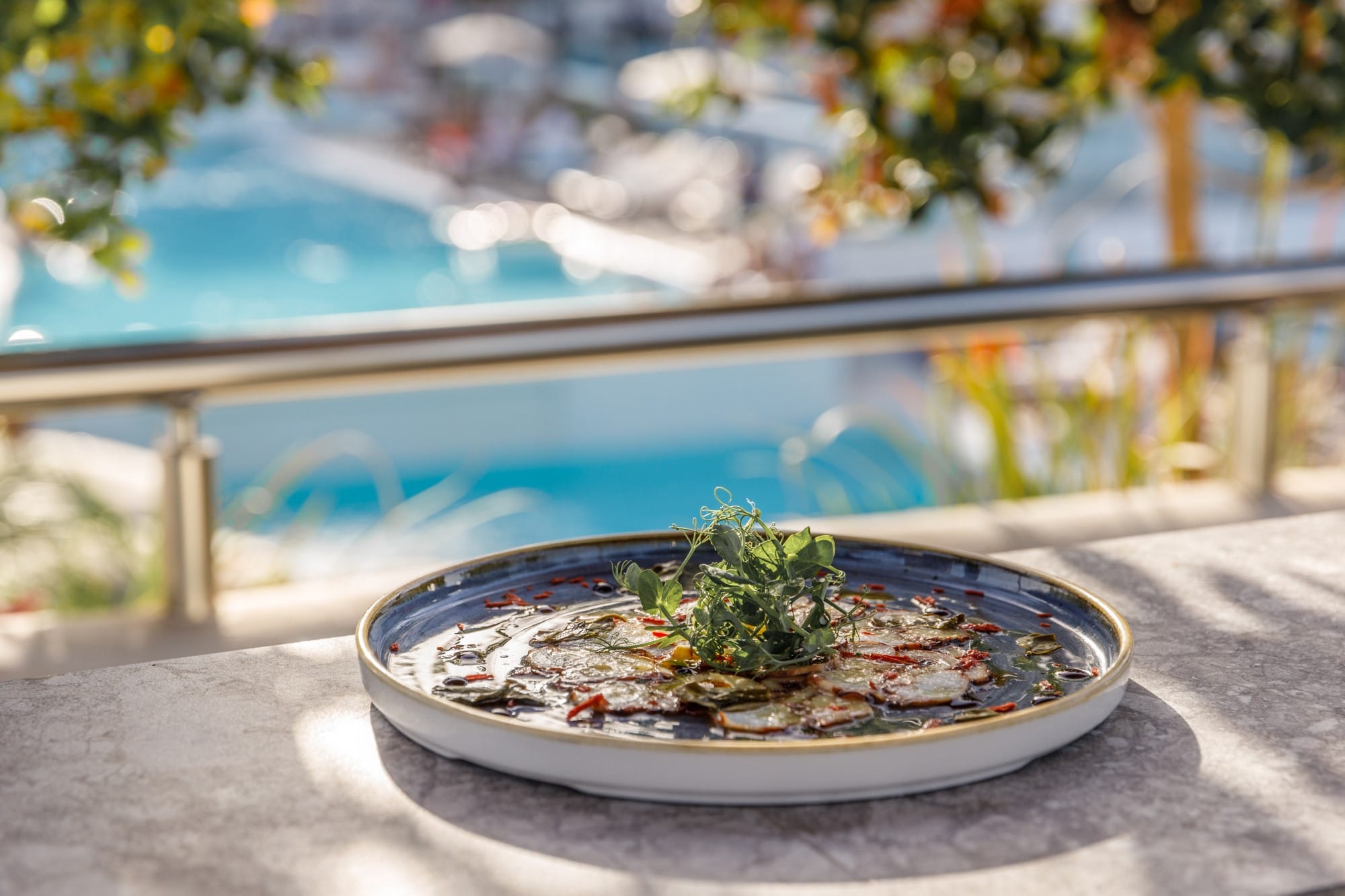 a bowl of plants next to a pool