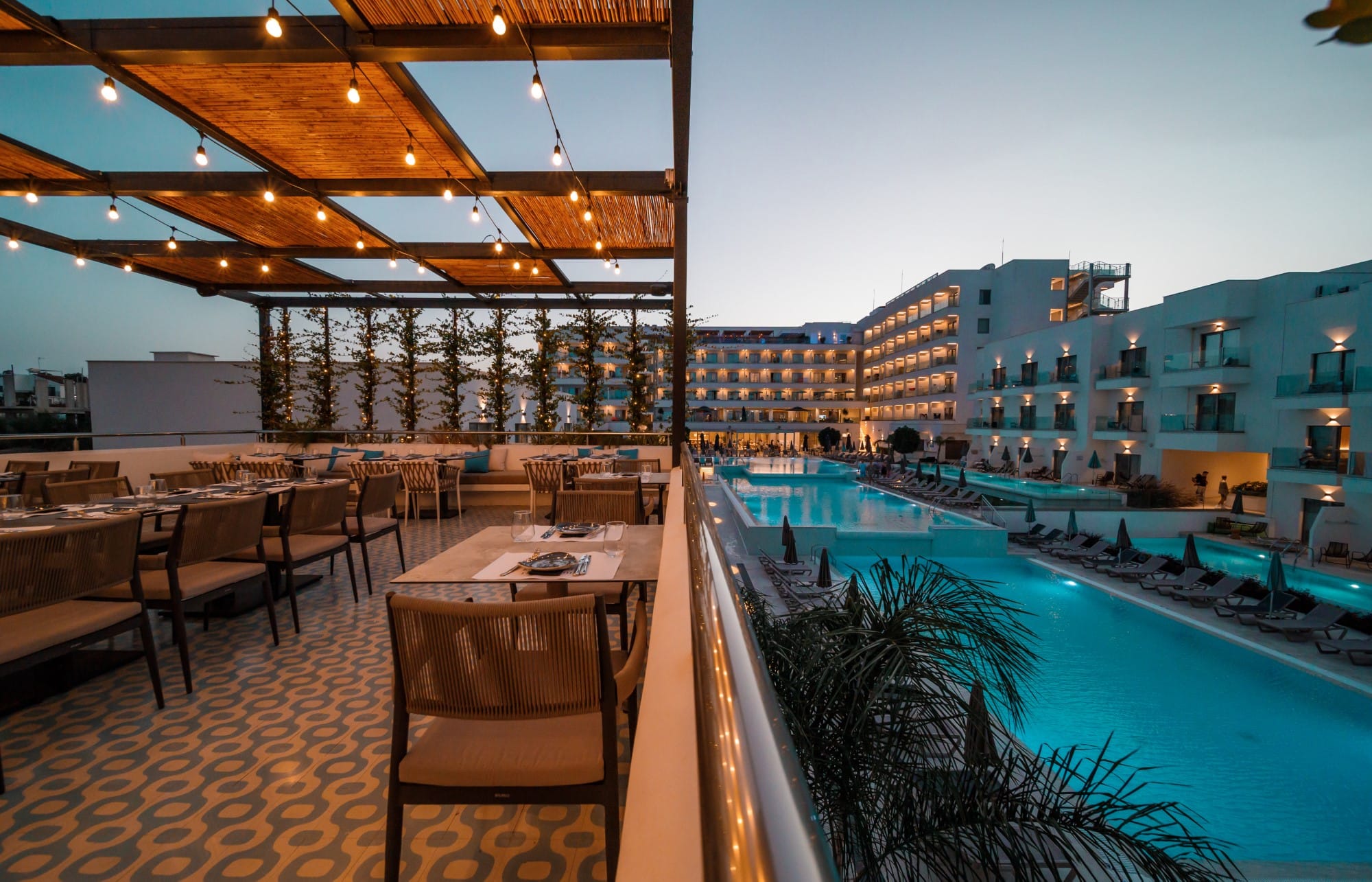 a pool with chairs and tables next to it