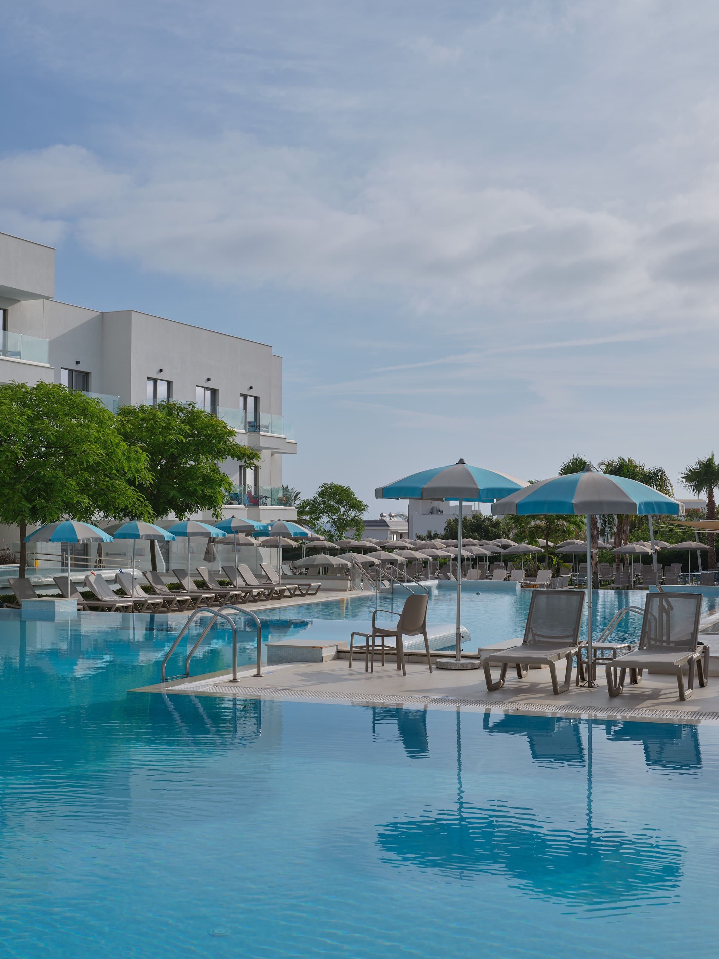 a pool with chairs and umbrellas