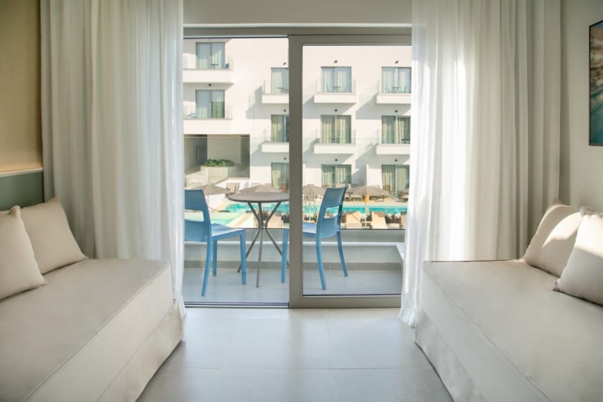 a room with a table chairs and a window with a view of a city