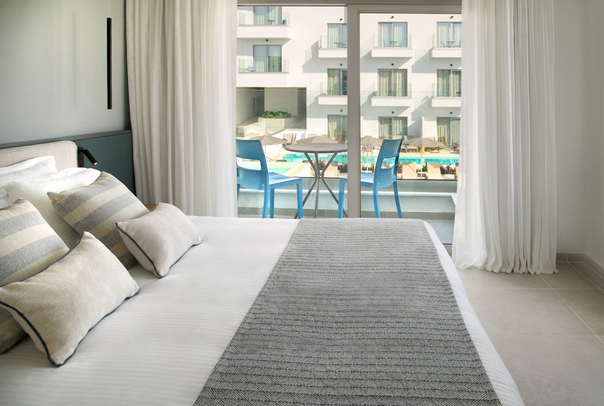 a room with a bed and chairs