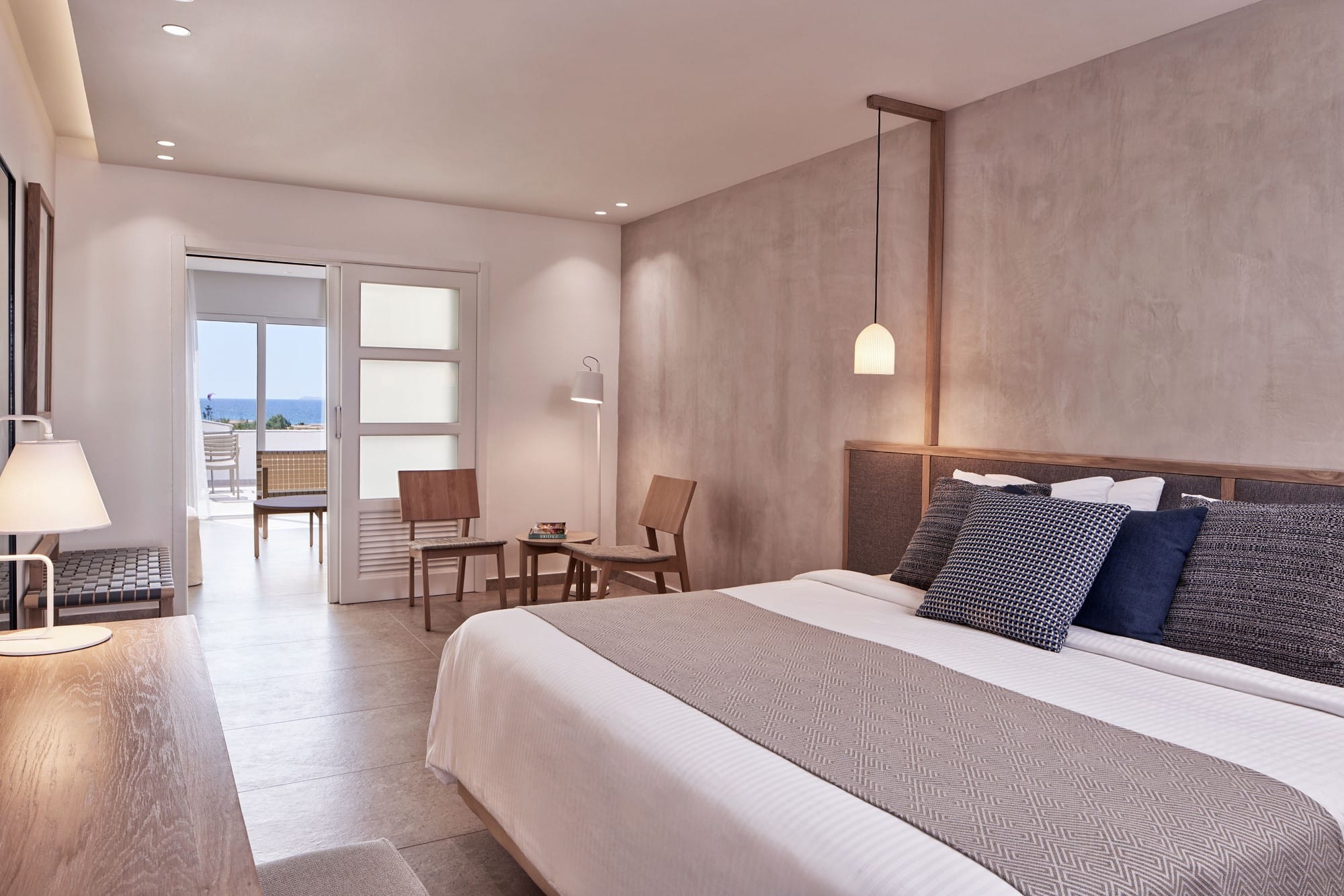 a bedroom with a bed and chairs