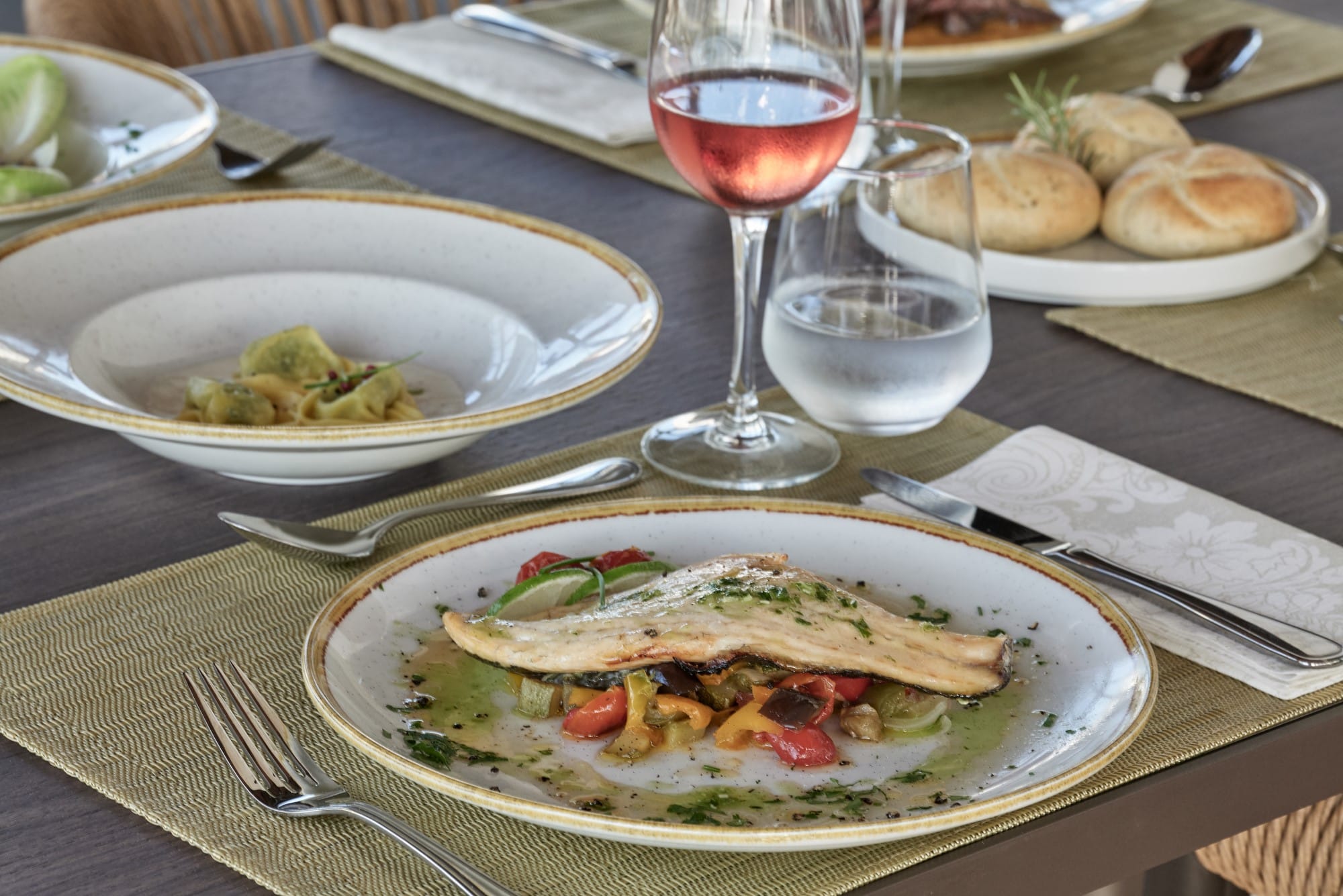 a plate of food and a glass of wine on a table